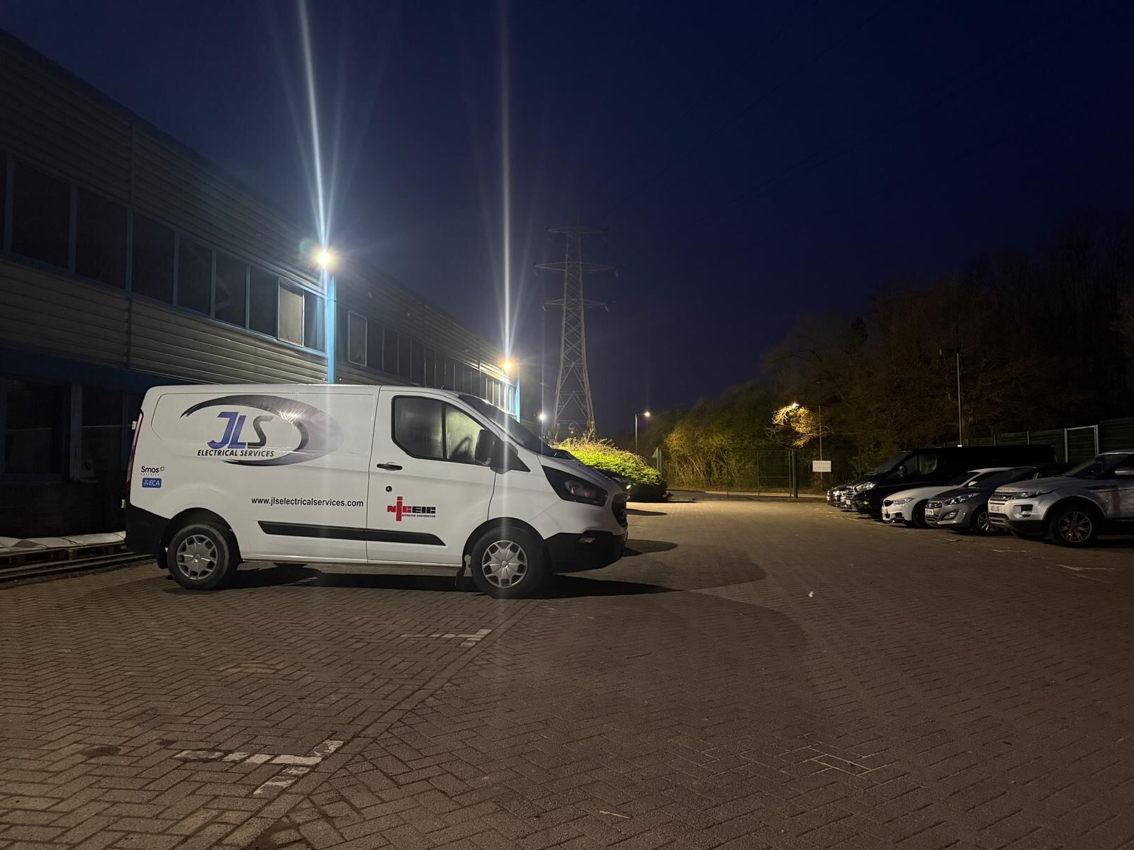 A JLS Electrical Services van on site at night